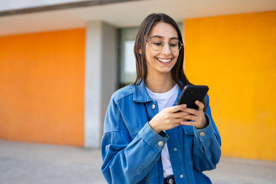 Young woman using smartphone on colorful urban background
