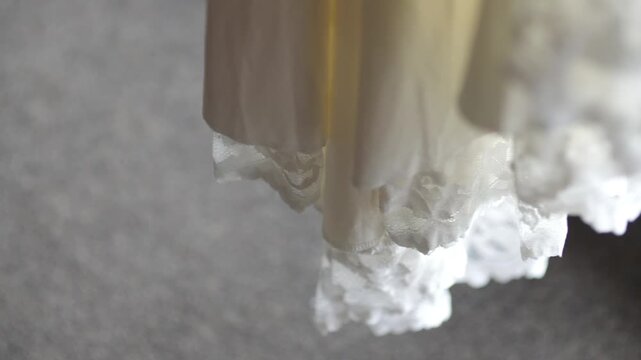 Lace hem of a light dress against a soft gray background