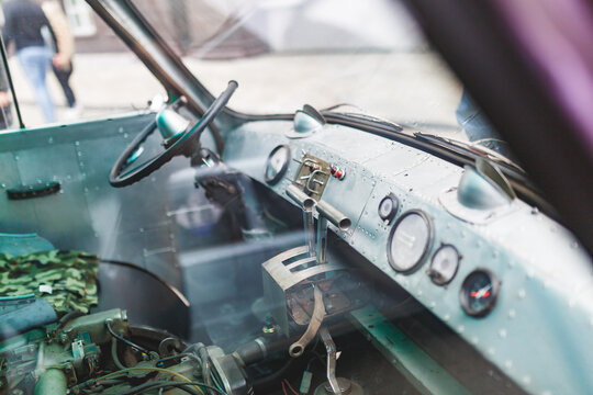 Vintage vehicle dashboard with worn steering and gauges