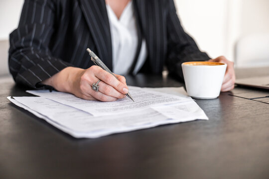 Businesswoman in office with coffee and documents