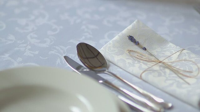 Elegant table setting with lavender sprig and folded napkin