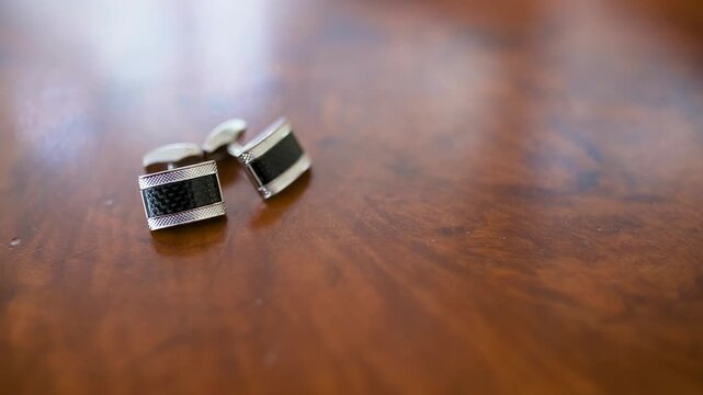 Metal cufflinks on a polished wooden surface