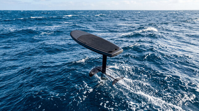 Professional POV shot looking down at a foilboard lifting above choppy blue ocean surface waters