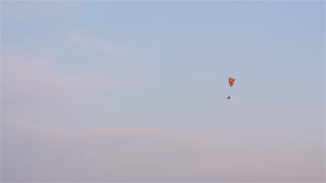 Solitary paraglider against a pastel evening sky