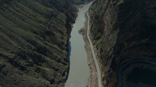 Drone footage of the confluence of the Avar Koysu and Andi Koysu rivers flowing through a deep mountain canyon in Dagestan, Russia, with a road along the river