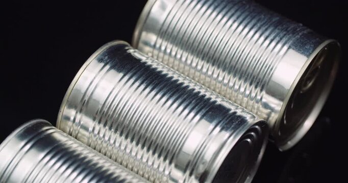 Shiny ribbed metal cans on a dark background