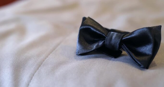 Black bow tie on light fabric with soft neutral lighting
