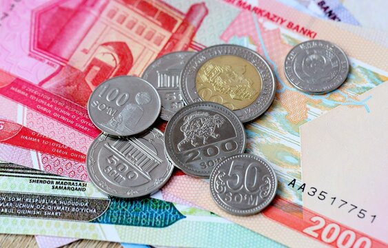 Uzbekistani som money bills and coins on table. Uzbekistan cash of UZS currency close up