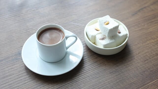 Close-up of traditional Turkish coffee served with delicious Turkish delight lokum on an elegant platter