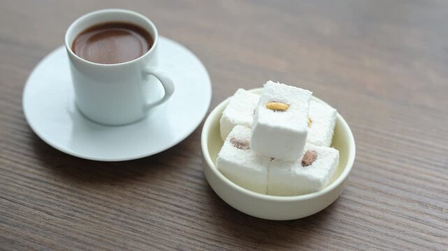 Close-up of traditional Turkish coffee served with delicious Turkish delight lokum on an elegant platter