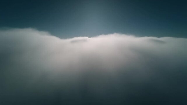 A serene landscape of clouds illuminated by sunlight from above.