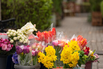 Small flower bouquets displayed for sale on a busy street, colorful fresh blossoms arranged by vendor, urban marketplace atmosphere, seasonal floral trade, and outdoor commerce concept. © Daniel