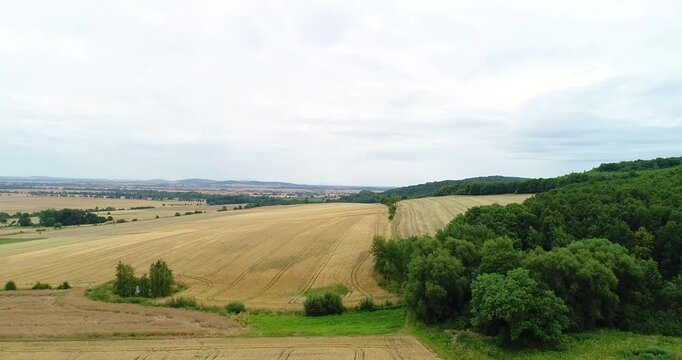 Aerial View of Farmland Beside Forested Hills