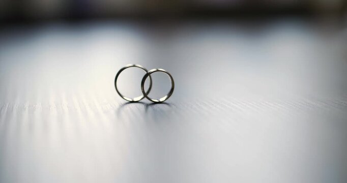Interlocked wedding rings on reflective surface
