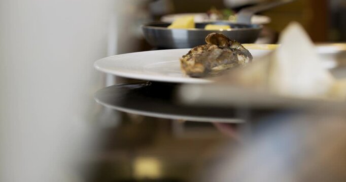 Plated fish dish served on a white plate in a warm kitchen setting