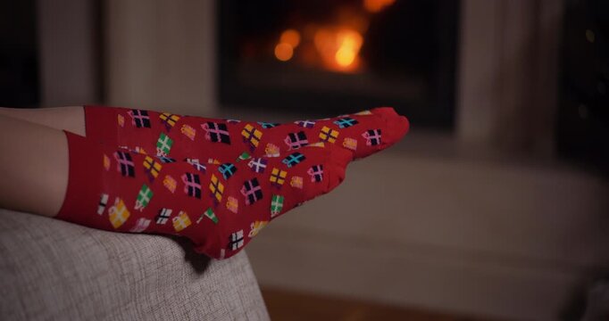Relaxed feet in socks by a glowing fireplace