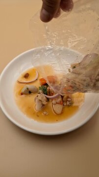 Pouring Yum Ruam Mit Thai Spicy Salad From Plastic Bag 4K Vertical