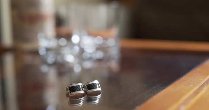 Silver cufflinks on a polished wooden table