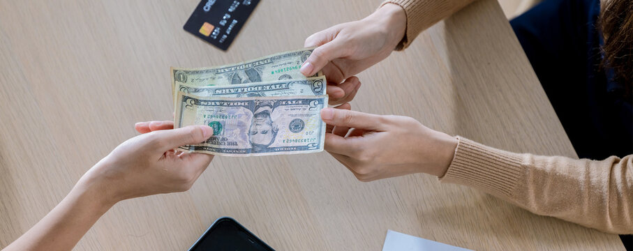 Customer handed the cash on bill paper. US dollar banknote tips in leather black bill reciept. USA Inflation concept.  image for background, wallpaper and copy space. bill checking and tips concept
