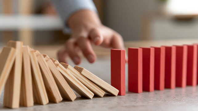 Domino Effect Interrupted by Red Block Between Falling and Standing Pieces
