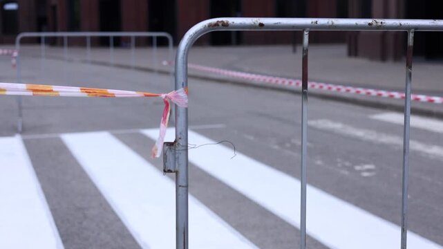 Road repair in the city. A metal roadwork grate and red and white warning tape marking a restricted area. road maintenance, public works, transportation infrastructure, urban safety