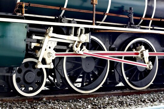 Close-up view of the intricate mechanical details of a vintage steam locomotive's wheels