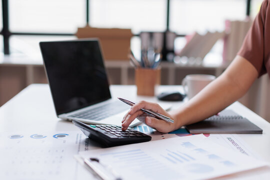 Businesswoman calculator analysis summary graph reports of business operating expenses and work data about the company's financial statements.
