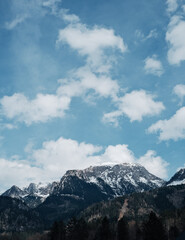 Obraz premium Snow-Covered Alpine Mountains Around Königssee, Berchtesgaden National Park, Bavaria, Germany, Scenic Landscape with Green Fir Trees, White Clouds and Blue Sky