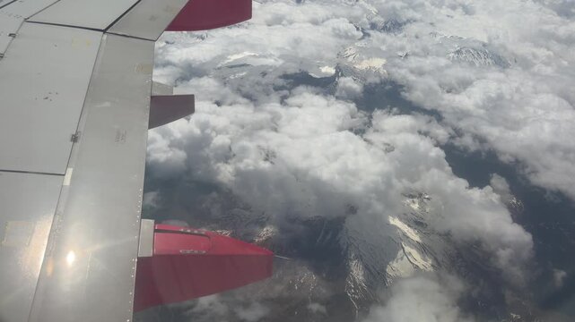 Airplane Wing Above Clouds: An aerial view from an airplane window showcases the majestic expanse of clouds from above, with a section of the aircraft's wing visible in the foreground.