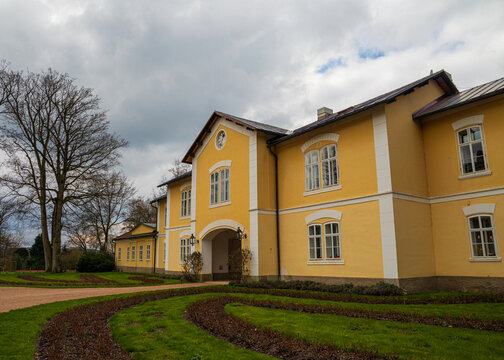 Historic yellow manor house with garden landscaping