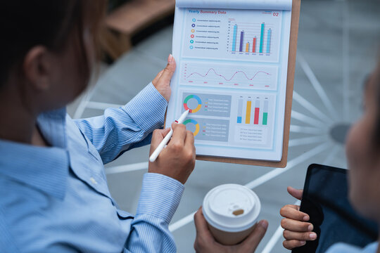 Financial planning discussion with data analysis on charts and graphs during business meeting showing teamwork and strategic decision making for success and growth