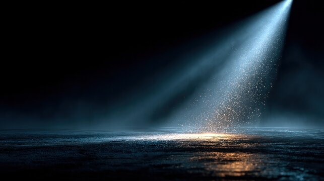 spotlight illuminating stage dust in darkness