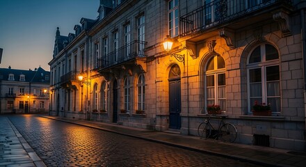 Obraz premium Historic European city street at dusk with warm lighting.