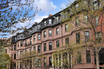 Fototapeta premium Row of old brownstone style apartment buildings with bay windows