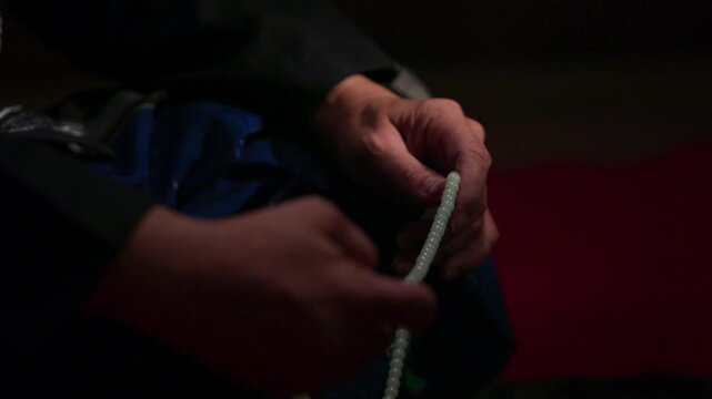 Close Up Hand Holding Prayer Beads While Performing Dhikr