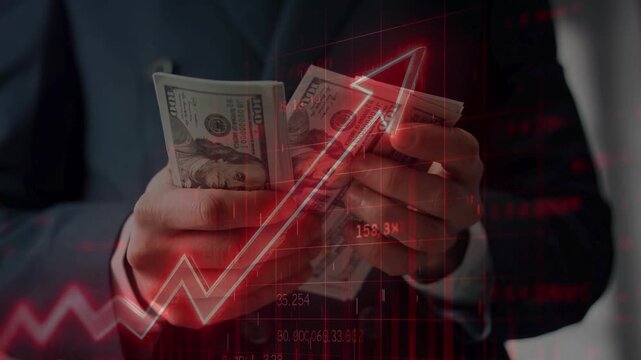 Businessman hands holding a stack of US 100 dollar bills with a glowing red upward jagged arrow and digital charts overlay. Representing financial growth.