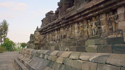 Fototapeta premium Close up perspective of ancient stone carvings and decorative relief panels on the walls of Borobudur temple structure
