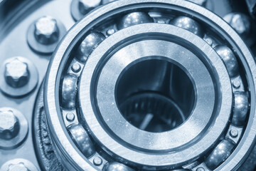 Obraz premium Close-up of a high-precision rolling bearing assembly process within an automotive part in a blue-toned scene.