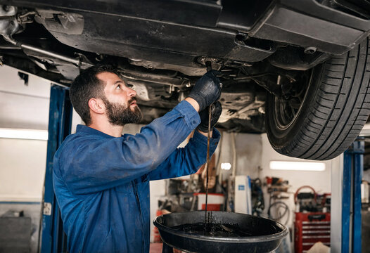Professional mechanic changing car oil in a modern auto repair shop