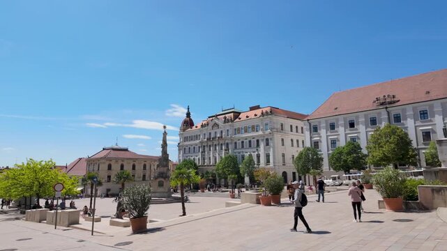P&eacute;cs, Hungary &ndash; May 1, 2026: Wide view of Sz&eacute;chenyi Square with pedestrians, historic buildings and vibrant urban atmosphere