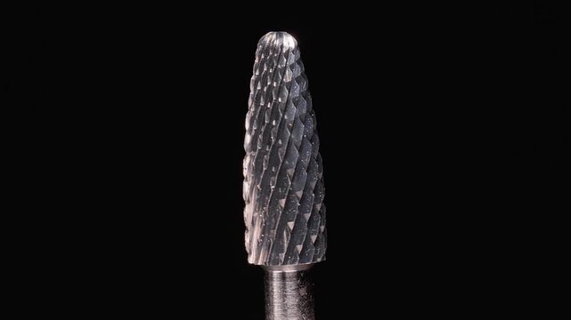 Professional Manicure Drill Bit With Sharp Metal Texture, Macro Slow Motion Rotation of Carbide Nail Tool on Black Background, Precision Beauty Equipment and Nail Care Industry