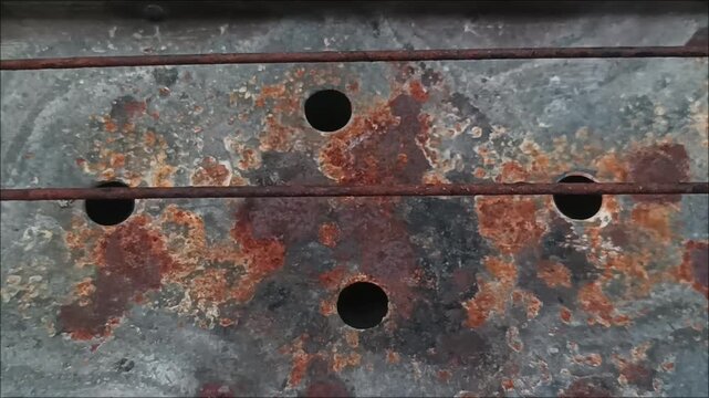 Old weathered rectangular metal charcoal grill with rust marks for traditional street food barbecue