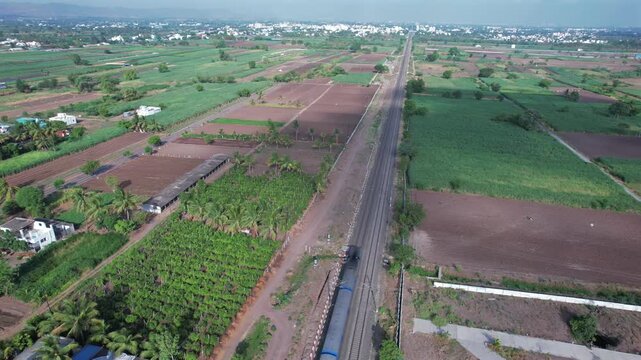 Aerial view of a local suburban commuter train in the countryside  near Pune India.