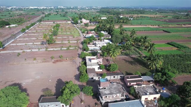 Breathtaking aerial drone view of a scenic rural village nestled in the lush green Western Ghats landscape near Pune, Maharashtra, India.