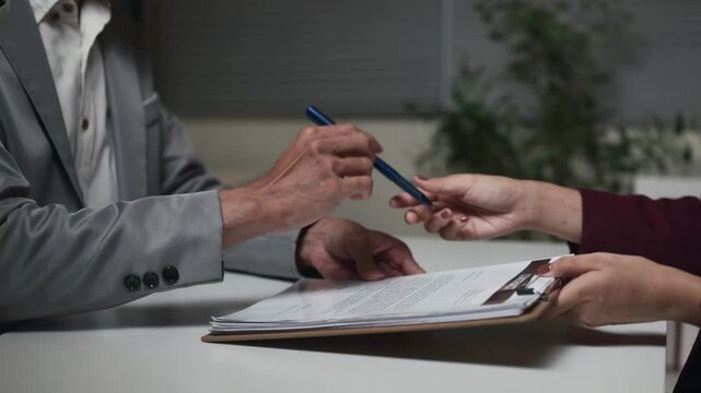 Business Meeting with Clasped Hands and Document Folder on Office Desk