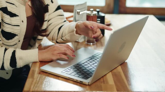 Woman Typing on Laptop at Home Kitchen Wooden Counter with Coffee Grinder in Background