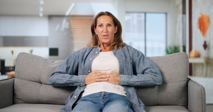 Mature Woman Sitting Calmly At Home Managing Her Acid Reflux