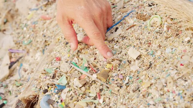 microplastics particles in beach sand, ocean pollution, close-up