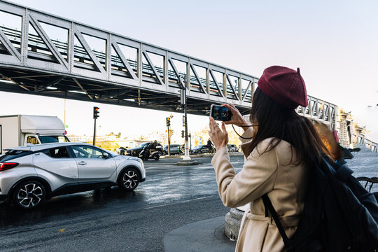 Woman traveling solo exploring paris taking urban landscape pictures