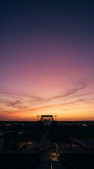 Fototapeta premium Beautiful sunset over industrial silhouette at horizon.